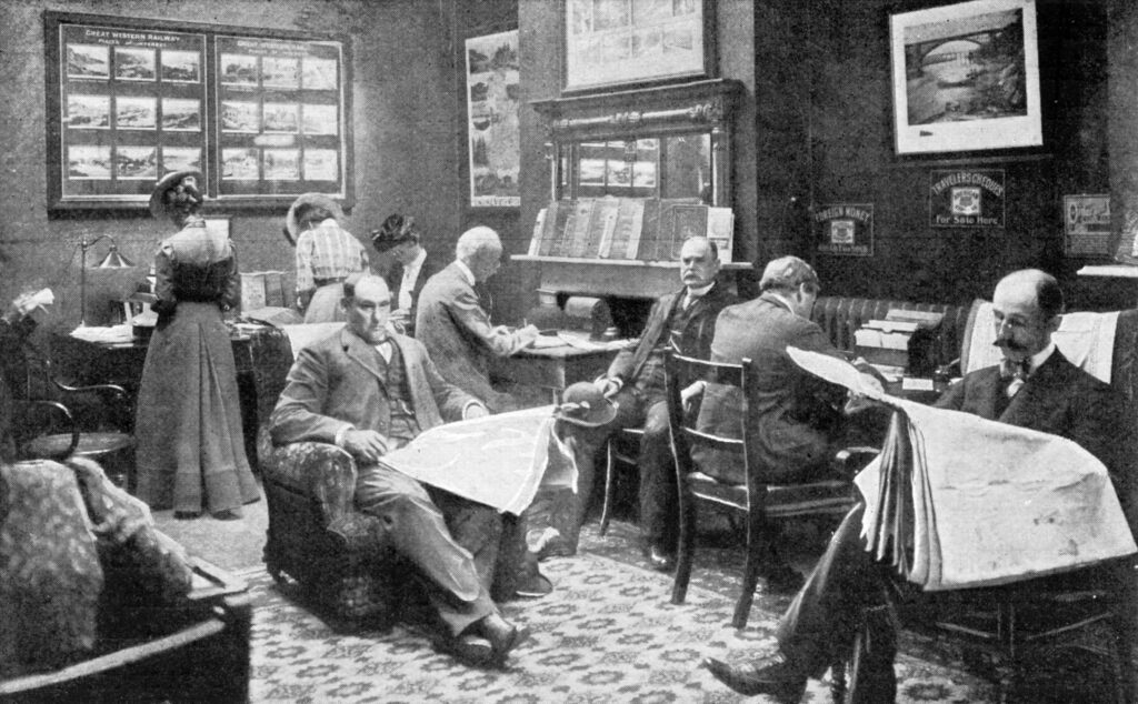 AdobeStock 162263870 A waiting room filled with people reading newspapers, writing, and browsing brochures. The room features wooden furniture, travel posters, and informational displays, suggesting a travel or railway office.